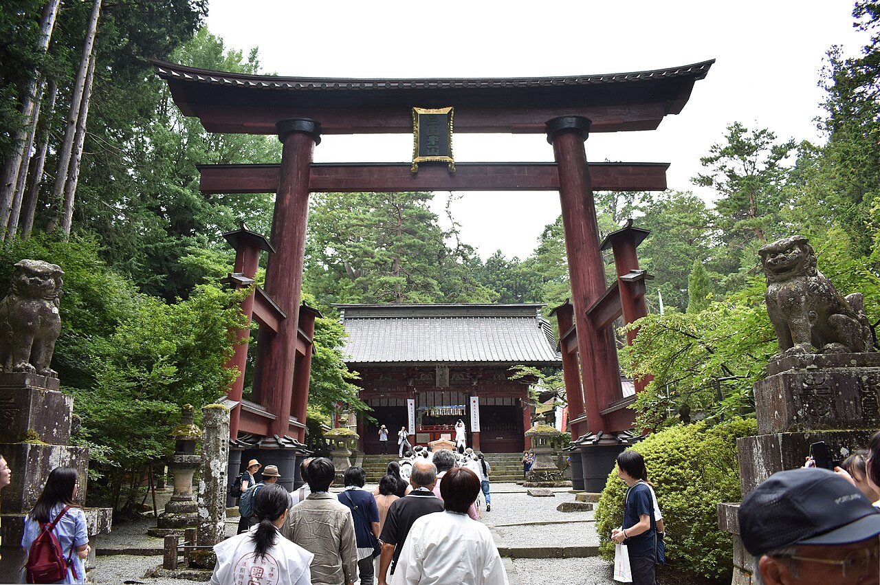 Arakurayama Sengen Shrine Kawaguchiko — rows of red stone lanterns and vermilion torii gates beneath tall cedar trees leading to Chureito Pagoda