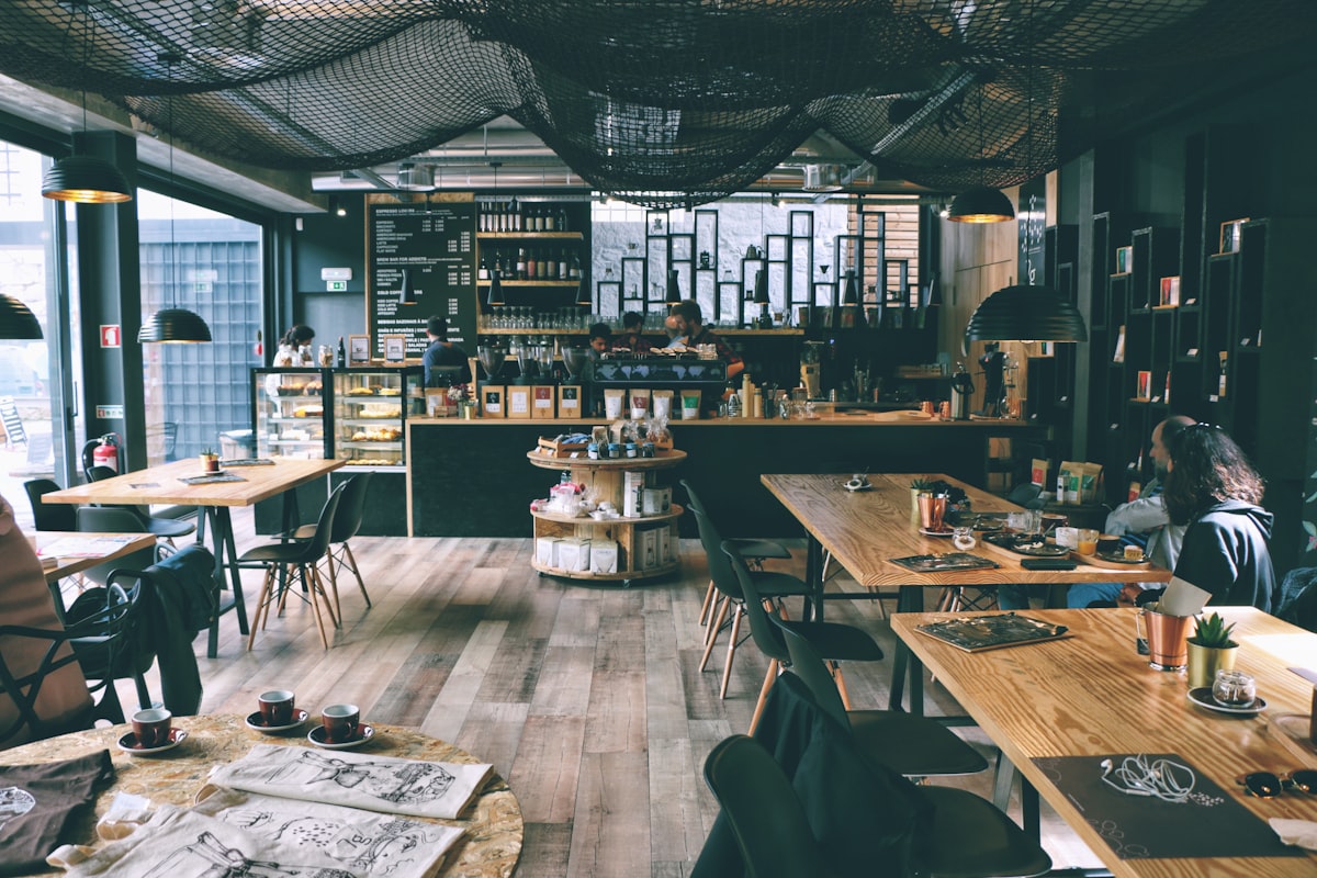 ภายในคาเฟ่ roastery ในไทเป โต๊ะไม้ เก้าอี้ และเคาน์เตอร์บาร์กาแฟพร้อมขวดเมล็ดกาแฟเรียงราย
