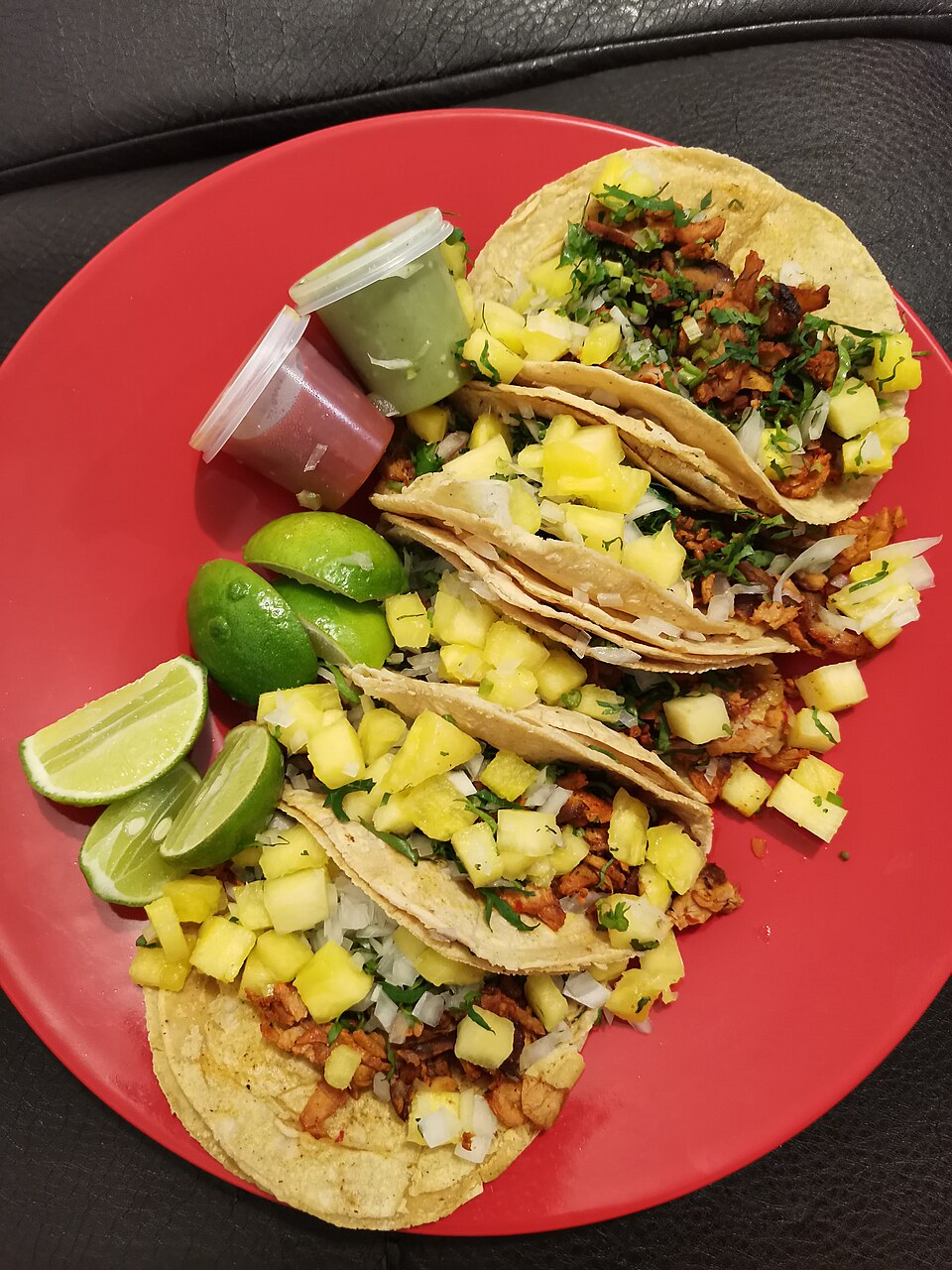 ทาโก้ al pastor หมูย่างเสียบแท่งหมักพริกแดงโรยสับปะรดและผักชี