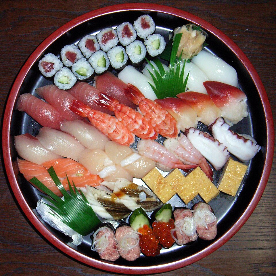 ซูชิและซาชิมิจัดเรียงบนจานไม้สวยงาม