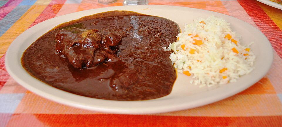 โมเล ซอสสีน้ำตาลเข้มราดบนไก่กับงา