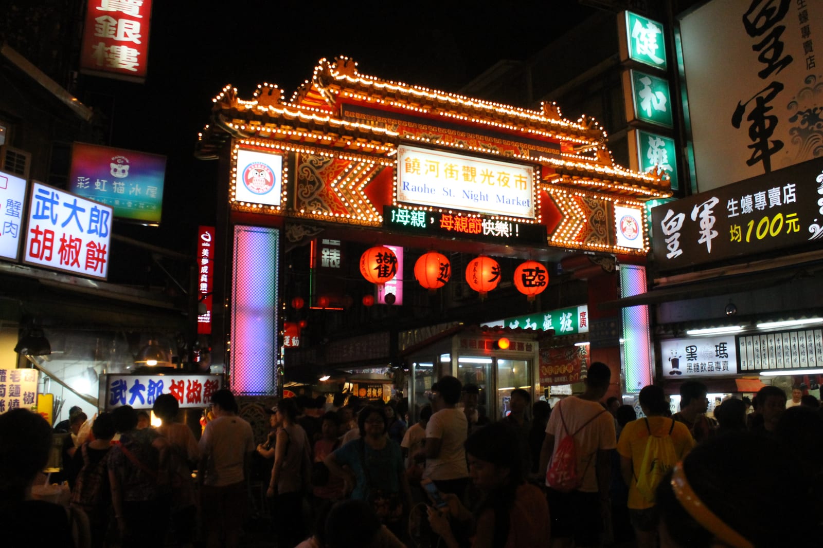 The golden temple-style dragon gate at the entrance to Raohe Street Night Market, Taipei, at night
