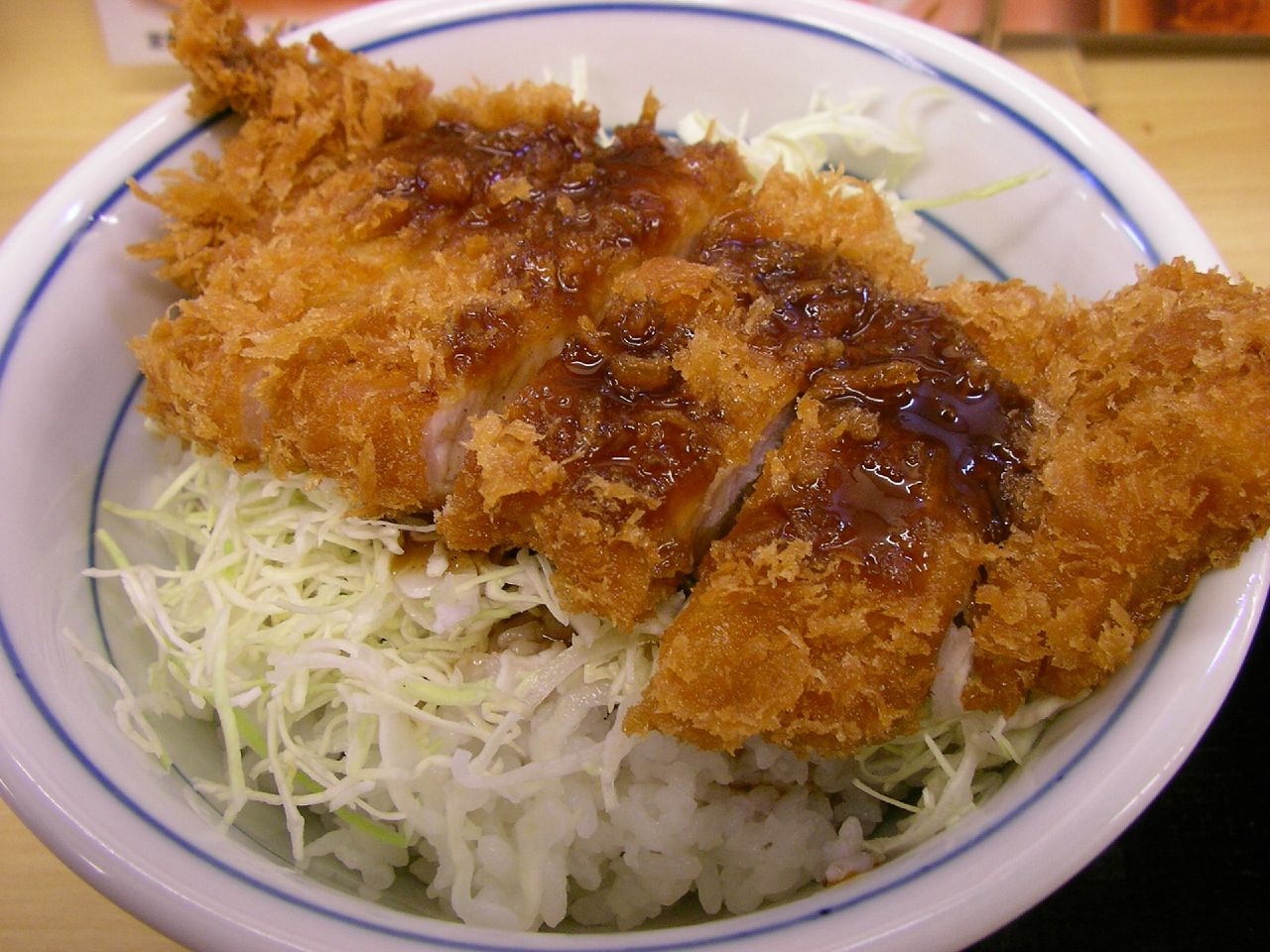 คัตสึด้ง หมูชุบเกล็ดขนมปังทอดราดซอส วางบนข้าวสวยกับกะหล่ำซอย