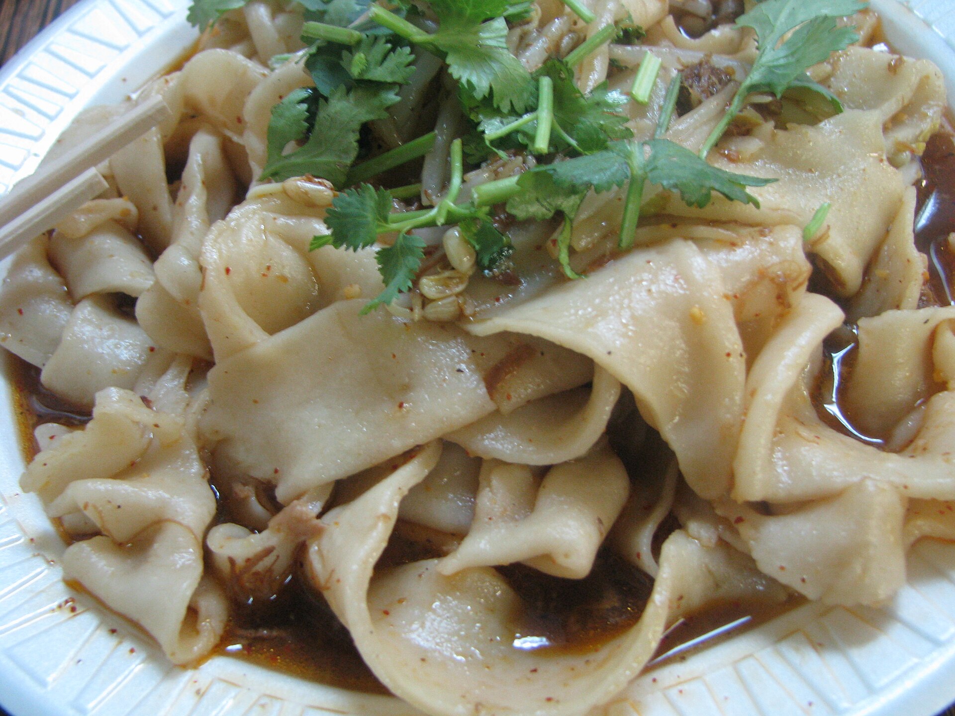 บะหมี่เบียงเบียง เส้นกว้างแบนเท่าเข็มขัดในชาม ราดน้ำมันพริก โรยถั่วงอกและผักชี