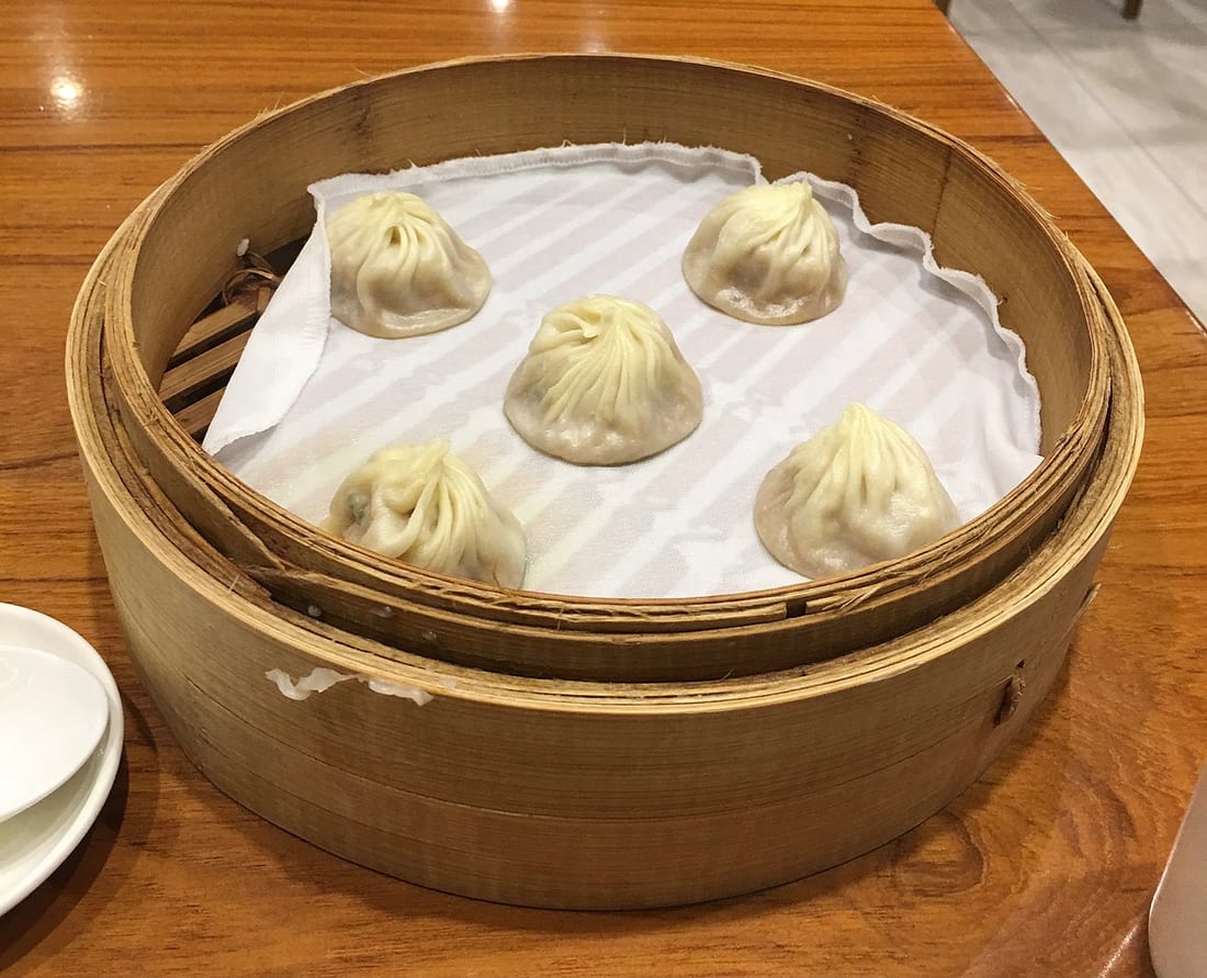 A bamboo steamer of xiaolongbao at Din Tai Fung, the pleated 18-fold soup dumplings lined up inside