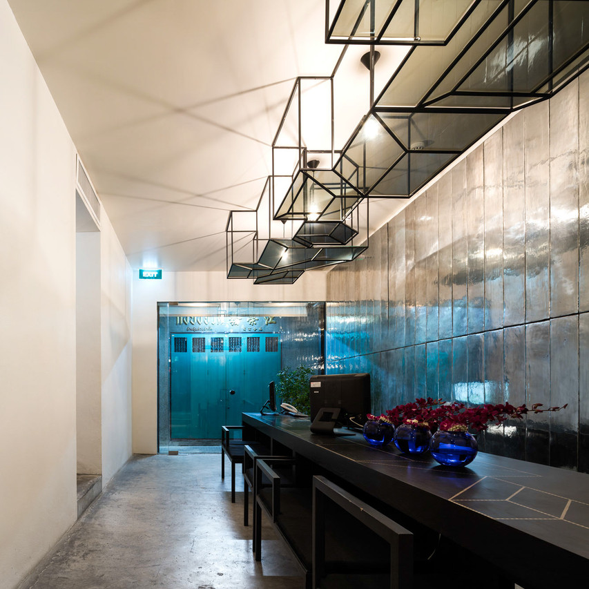 Reception desk with metallic-tiled wall and polished concrete floor
