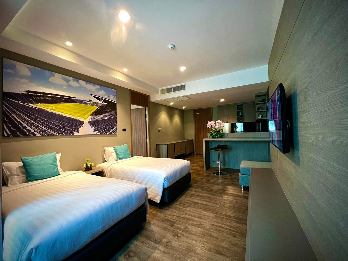 Deluxe Twin room with a large Chang Arena stadium photo above the beds