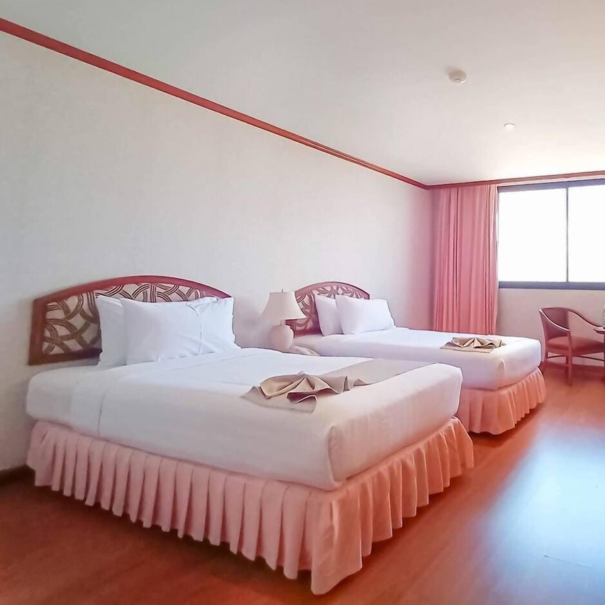 ห้องพักเตียงคู่ของ K.P. Grand Hotel เฟอร์นิเจอร์ไม้ พื้นไม้ ม่านสีพีช