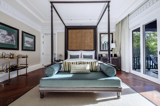 Colonial four-poster suite with polished teak floors and private terrace door