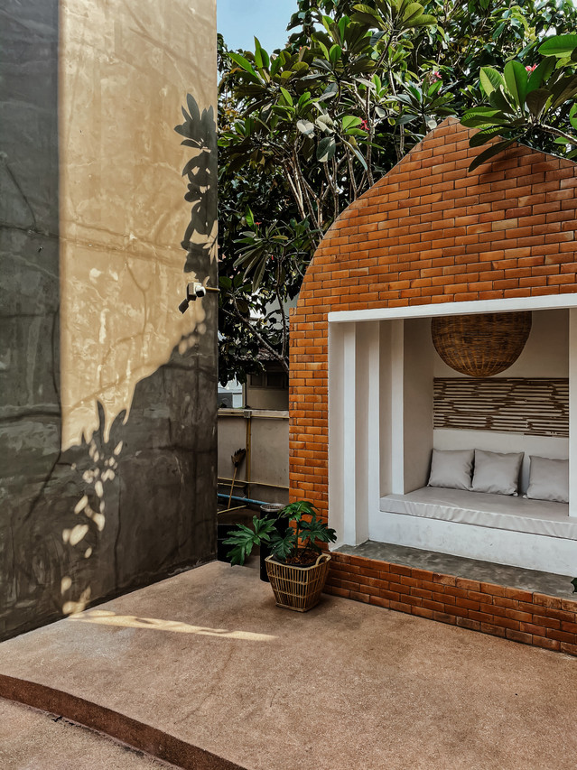Outdoor nook with Burmese brick archway in hotel courtyard