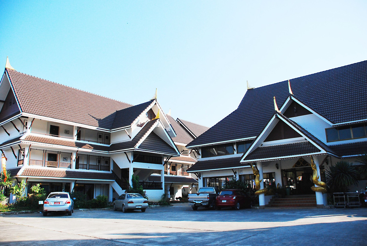 Teak buildings under Lanna tiled roofs at Nak Nakara Hotel Chiang Rai