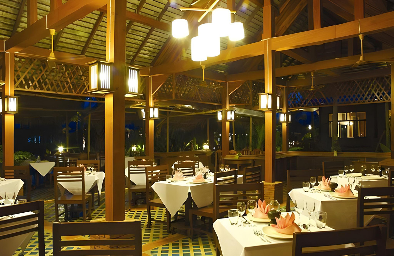 Baipho restaurant with teak posts and hanging lanterns in the evening