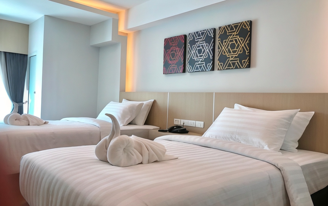 Clean, modern Deluxe Twin room with striped linens and geometric wall art