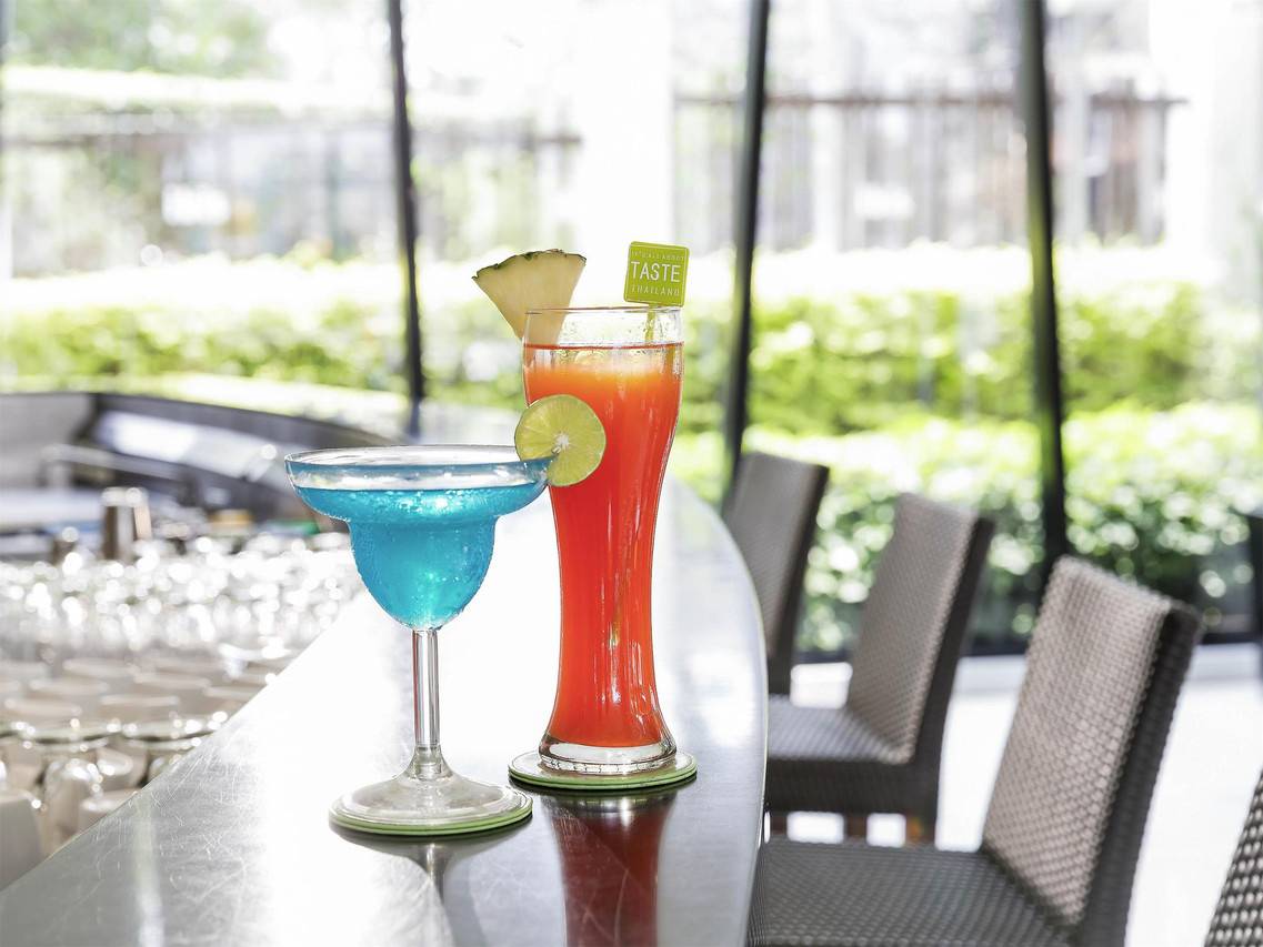 เครื่องดื่มที่บาร์ริมสระของ ibis Hua Hin มองเห็นสวนผ่านกระจก