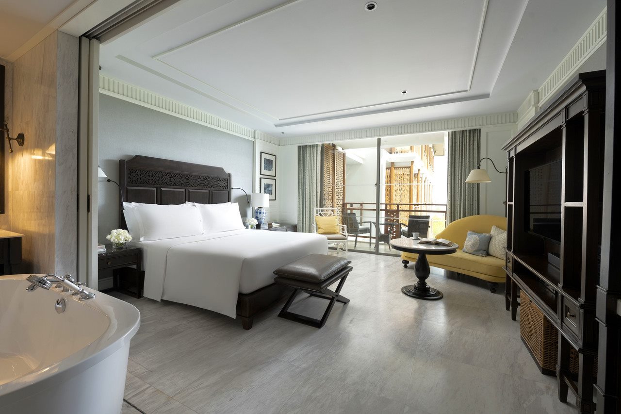King guest room with a wooden-screen balcony overlooking the resort garden