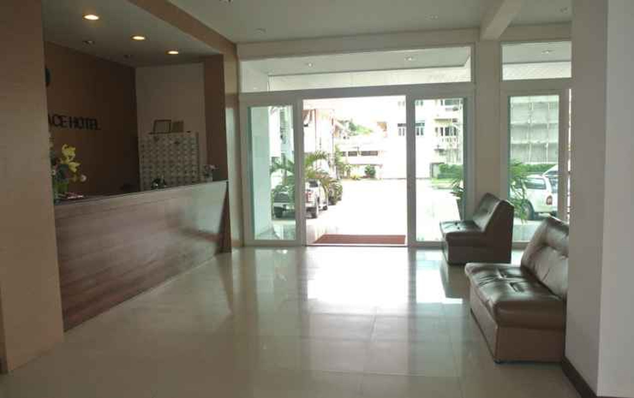 ล็อบบี้และเคาน์เตอร์ต้อนรับของ Phaiboon Place Hotel มีป้ายชื่อโรงแรมบนผนัง