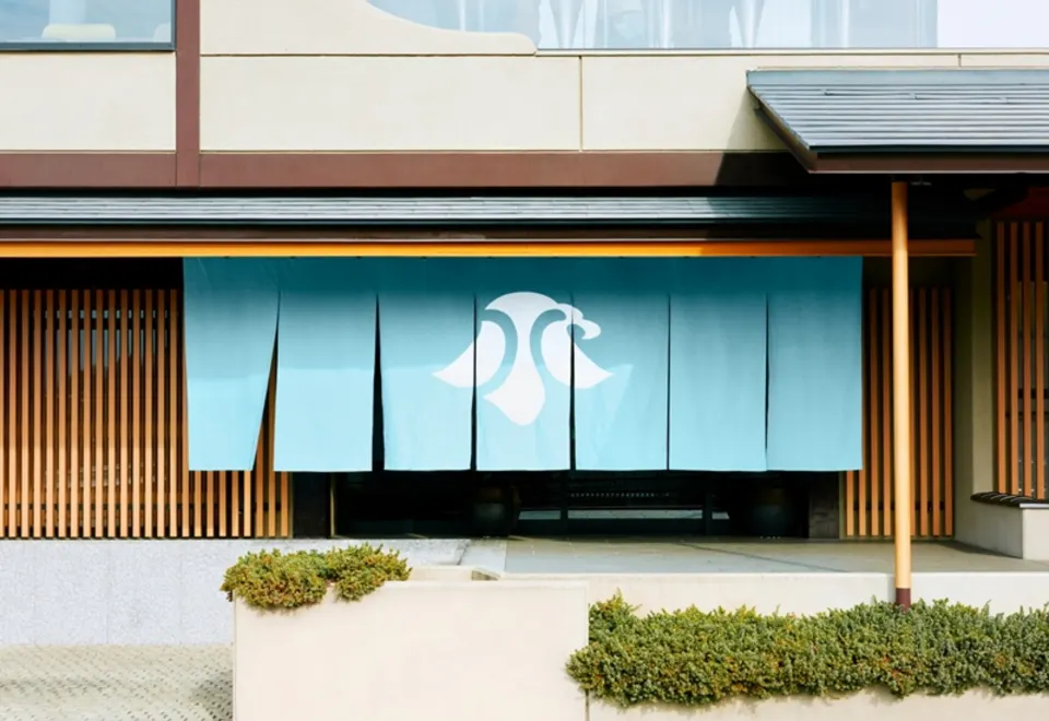 Traditional noren (entrance curtain) bearing the Ubuya crane crest at the ryokan entrance
