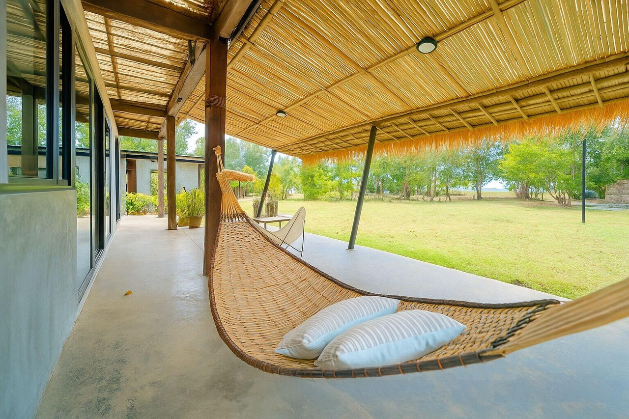 ระเบียงคาบาน่าพร้อมเปลสานมองออกสวนและทะเล
