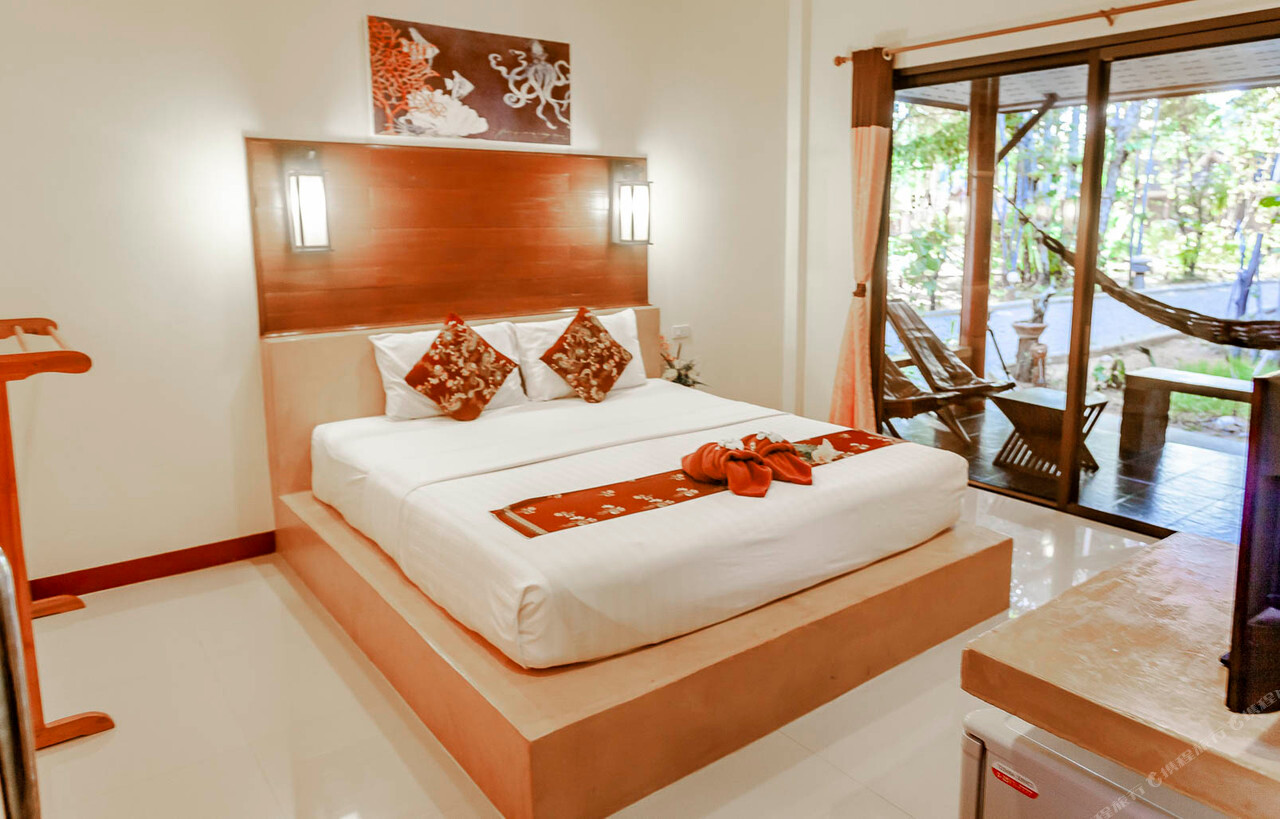 ห้องบังกะโลภายใน เตียงไม้ ประตูกระจกออกระเบียงที่มีเปลญวน
