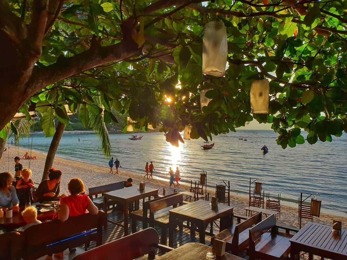 ร้านอาหารริมหาดใต้ร่มไม้พร้อมโคมไฟยามเย็น มองออกอ่าวหาดสลัด