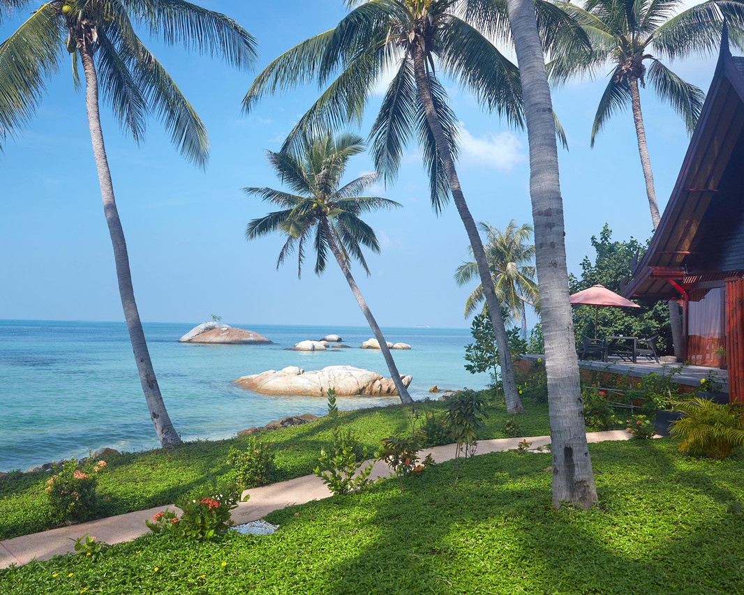 Red-roofed Balinese-style villa on a garden above the west-coast beach