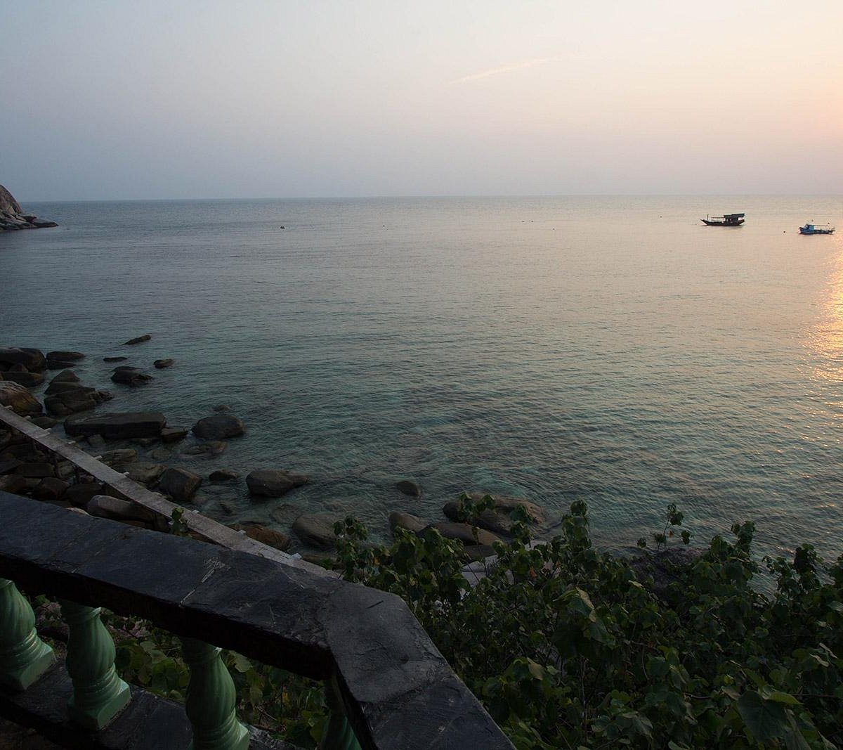View from the resort terrace down to the rocks and sea at dusk