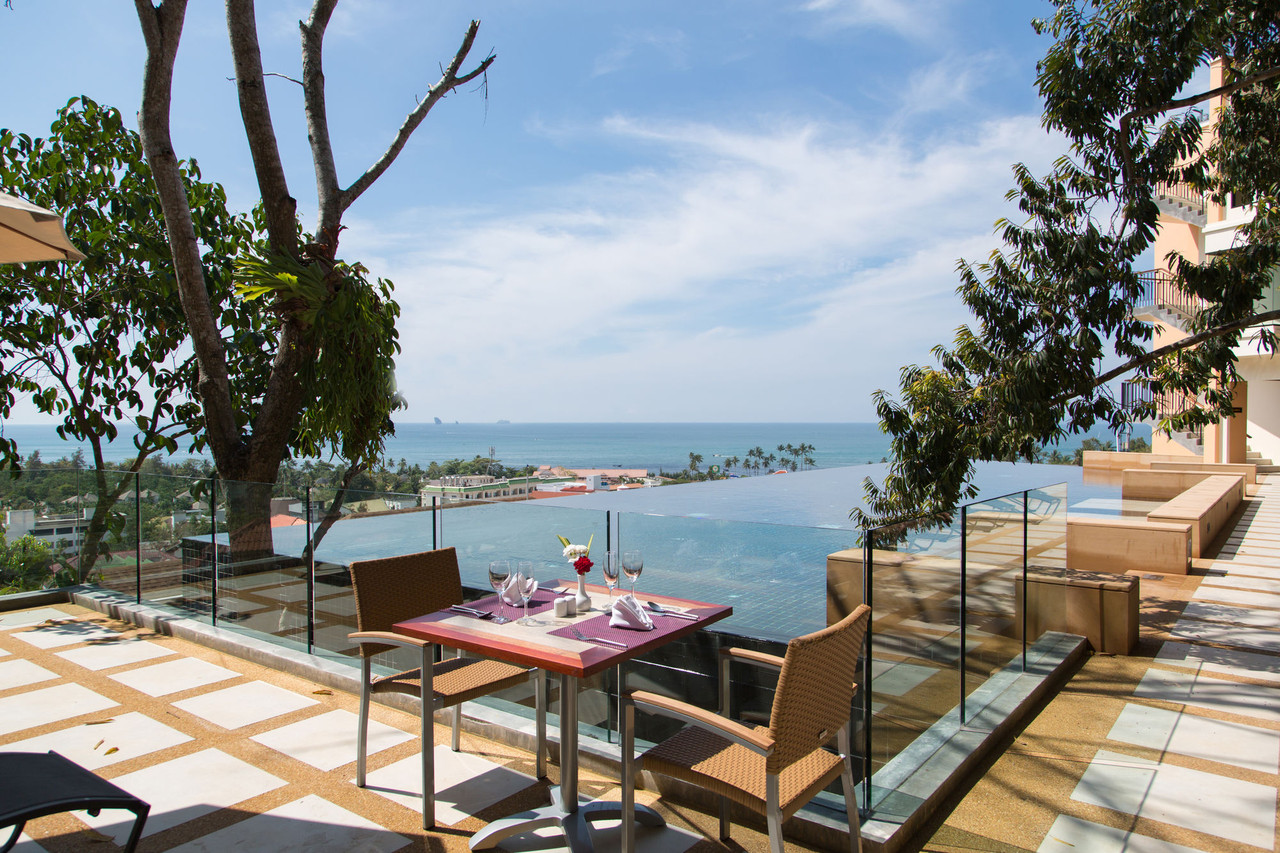 Rooftop infinity pool and poolside dining with limestone karst views
