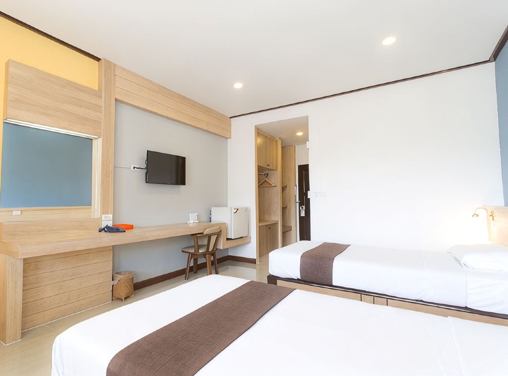 ห้องพักเตียงคู่ของ Asia Lampang Hotel ผนังไม้อ่อน โต๊ะทำงานยาว