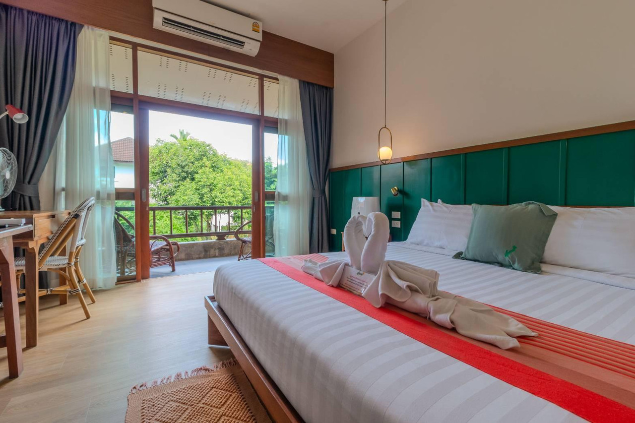 ห้องพักมีระเบียงไม้มองเห็นสวนเขียวที่ Auangkham Resort ลำปาง