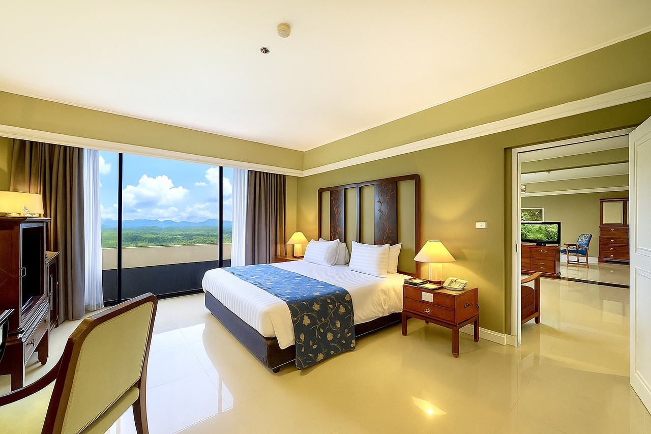 ห้อง Grand Deluxe ของ Loei Palace Hotel พร้อมกระจกบานใหญ่มองเห็นวิวภูเขา