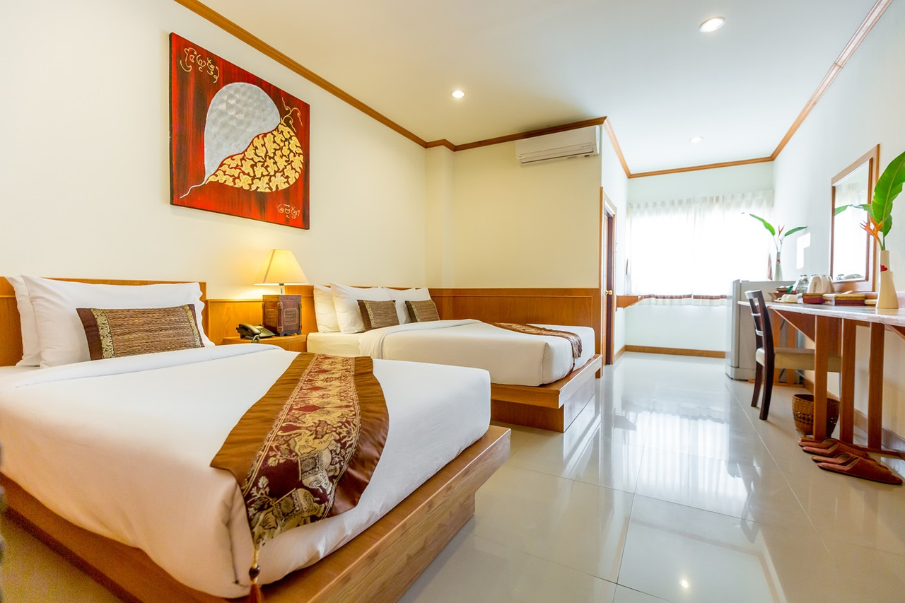 Superior Twin room with teak trim and an Isan-style bodhi-leaf painting