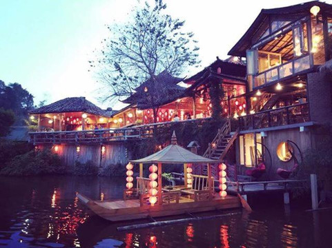 Lakeside clay-house village at Ban Rak Thai at dusk, red lanterns reflected on the water
