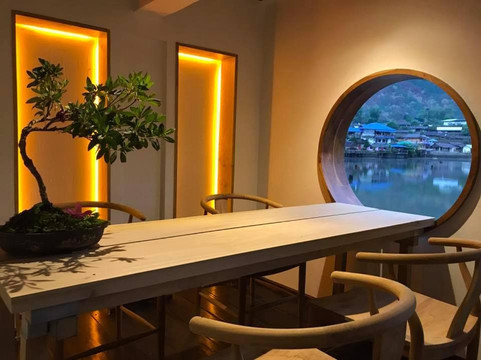 Dining room with a round Chinese moon window framing the lake