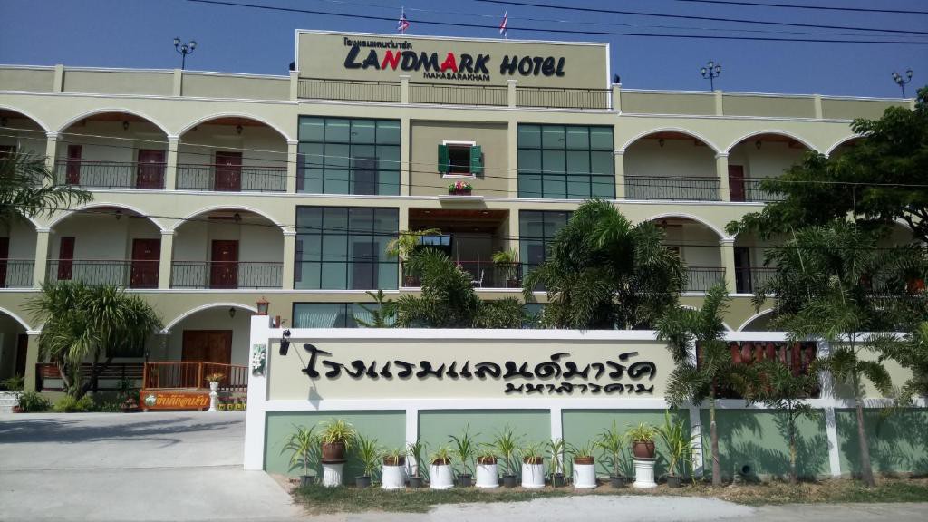 หน้าตึก Landmark Maha Sarakham ตอนกลางวัน เห็นป้ายโรงแรมและระเบียงโค้งสไตล์สแปนิช