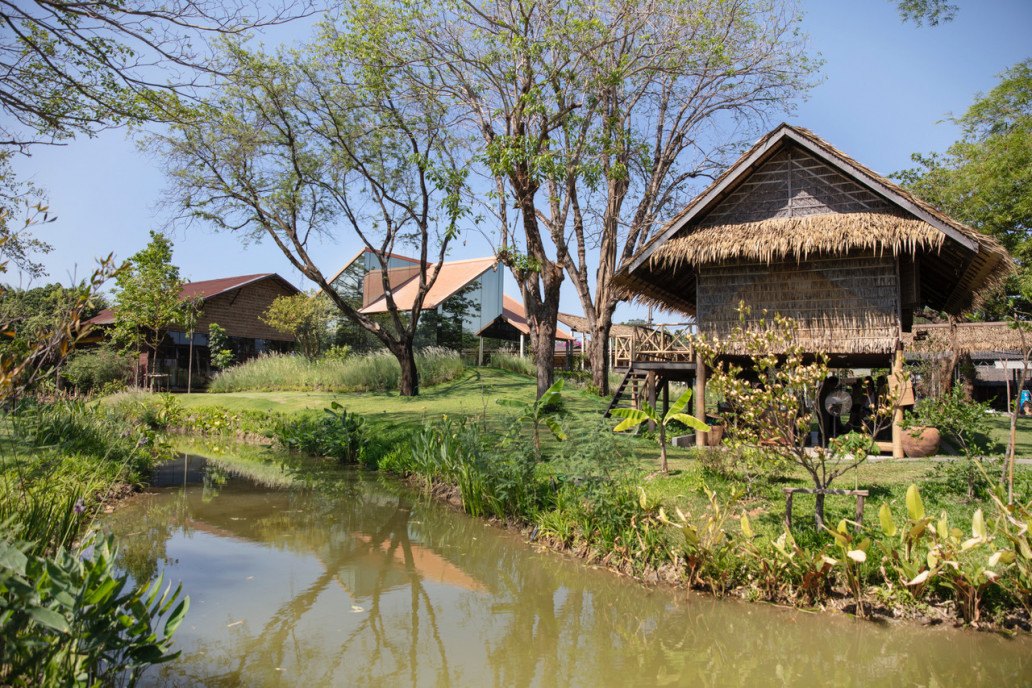 เรือนไทยมุงจากริมน้ำในสวนของ Sampran Riverside นครปฐม