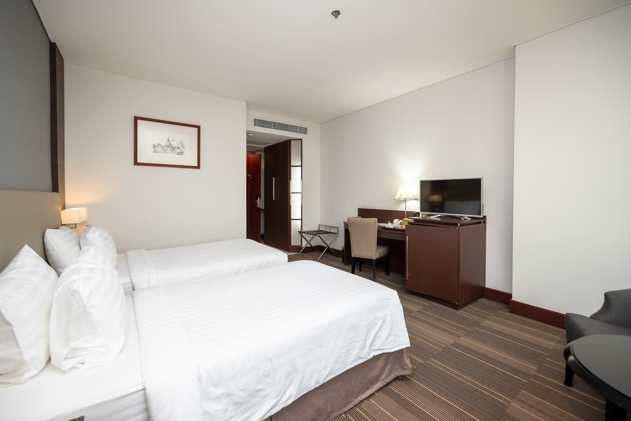 Fortune Hotel Korat guest room with twin beds, work desk and TV