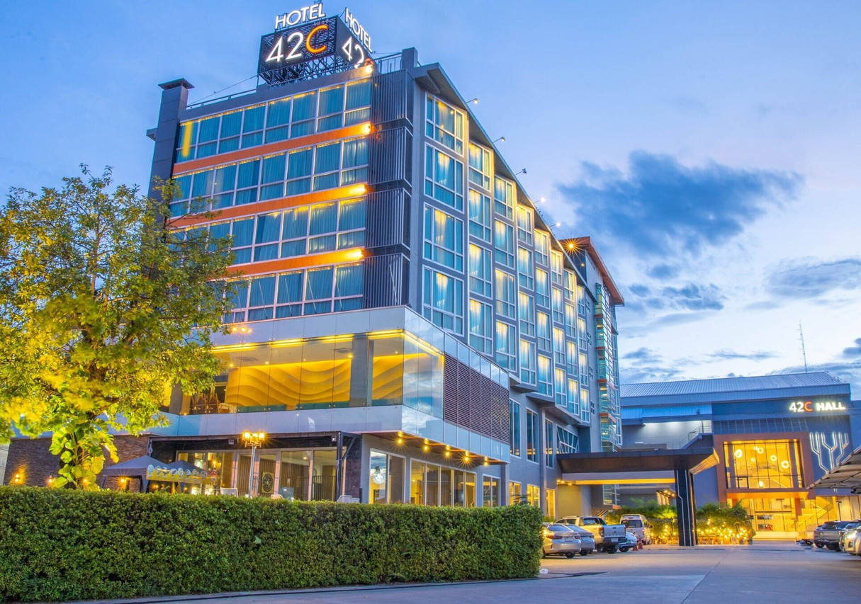 ตึกกระจก 42C The Chic Hotel ยามค่ำ ป้ายเรืองแสงและอาคาร 42C Hall ด้านข้าง