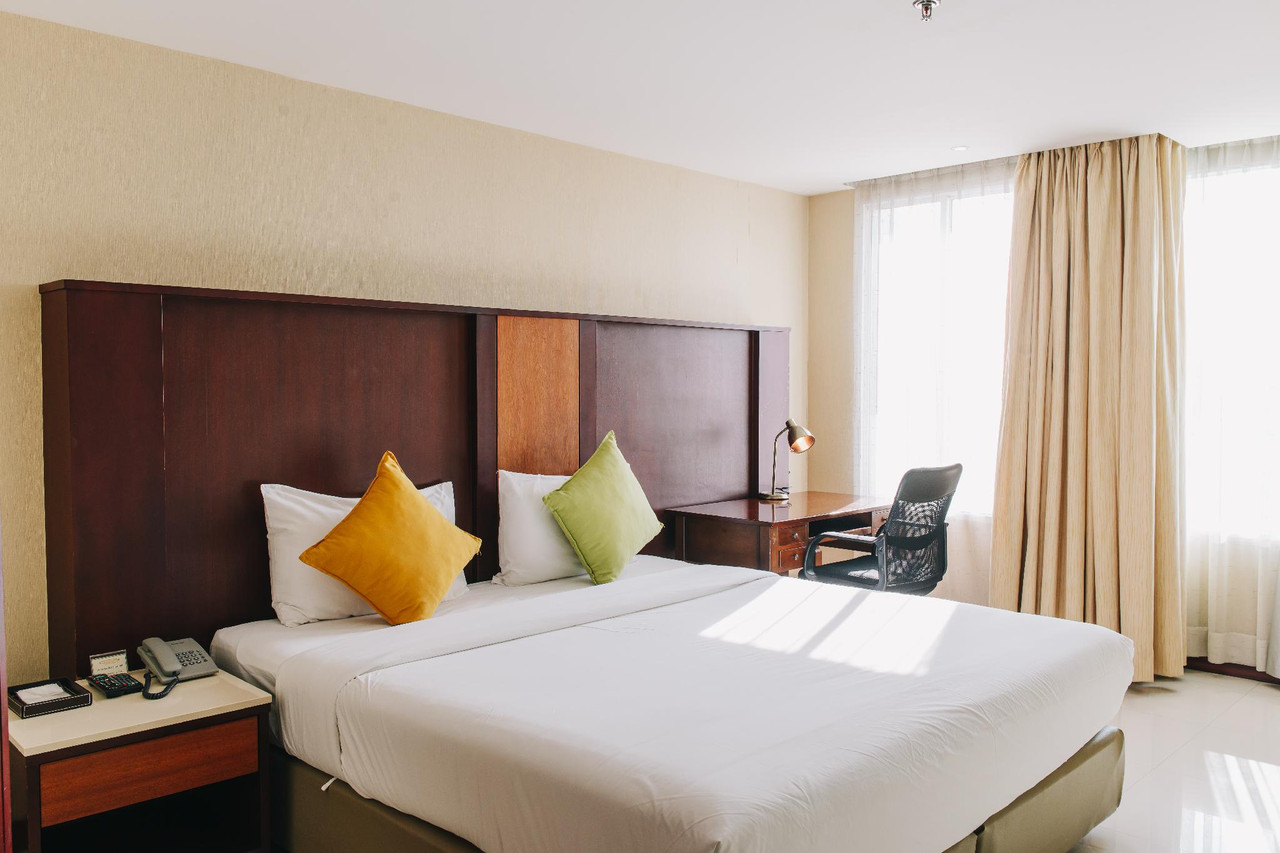 ห้องดีลักซ์ Aramis Hotel เตียงใหญ่ โต๊ะทำงาน หัวเตียงไม้