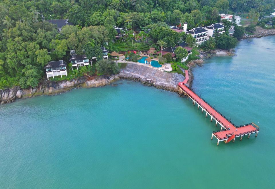 มุมสูงเห็น Racha Kiri Resort บนหน้าผาริมทะเล สะพานไม้สีแดงยื่นลงอ่าว