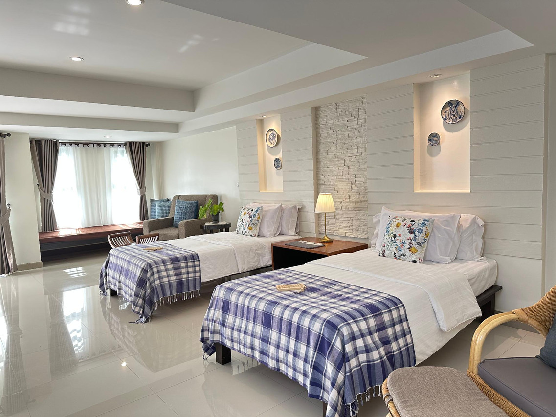 ห้อง Tazs Deluxe ขนาด 50 ตร.ม. เตียงแฝดและจานเซรามิกน่านบนผนัง