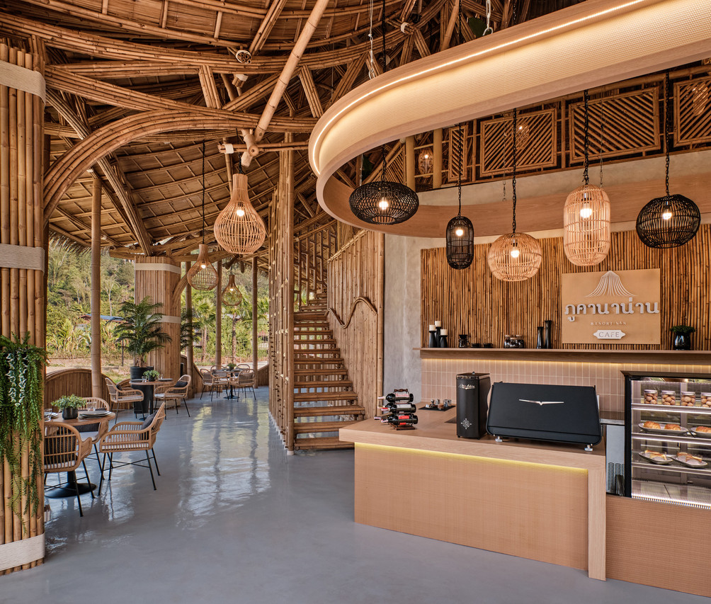 Giant-bamboo cafe interior with the Phukananan counter sign and hanging rattan lamps
