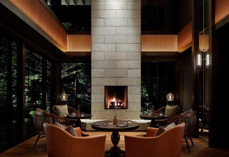 Lobby Lounge ของ The Ritz-Carlton Nikko พร้อมเตาผิงและวิวป่าสนยามค่ำ