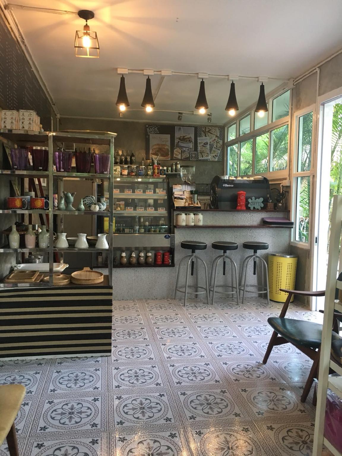 คาเฟ่ในตัวของที่พัก พื้นกระเบื้องลายดอก เครื่องชงกาแฟ และชั้นวางของวินเทจ