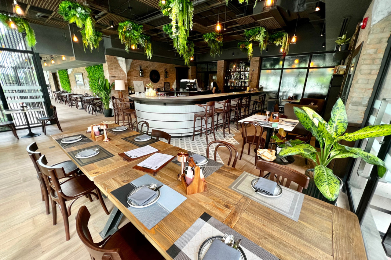 ร้าน Haute House Restaurant ตกแต่งด้วยต้นไม้ห้อยและบาร์กลางร้าน