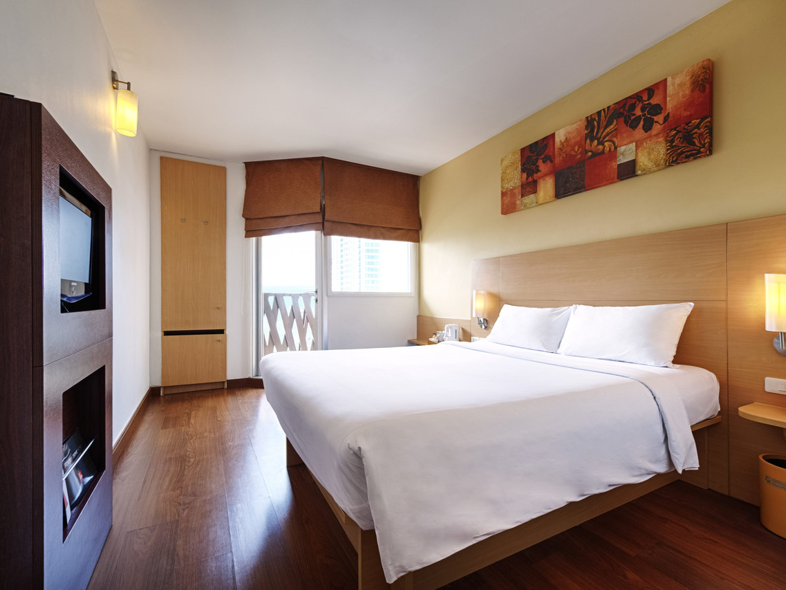 ห้อง Standard Double ของ Ibis Pattaya เตียงขาว พื้นไม้ ระเบียงเล็ก