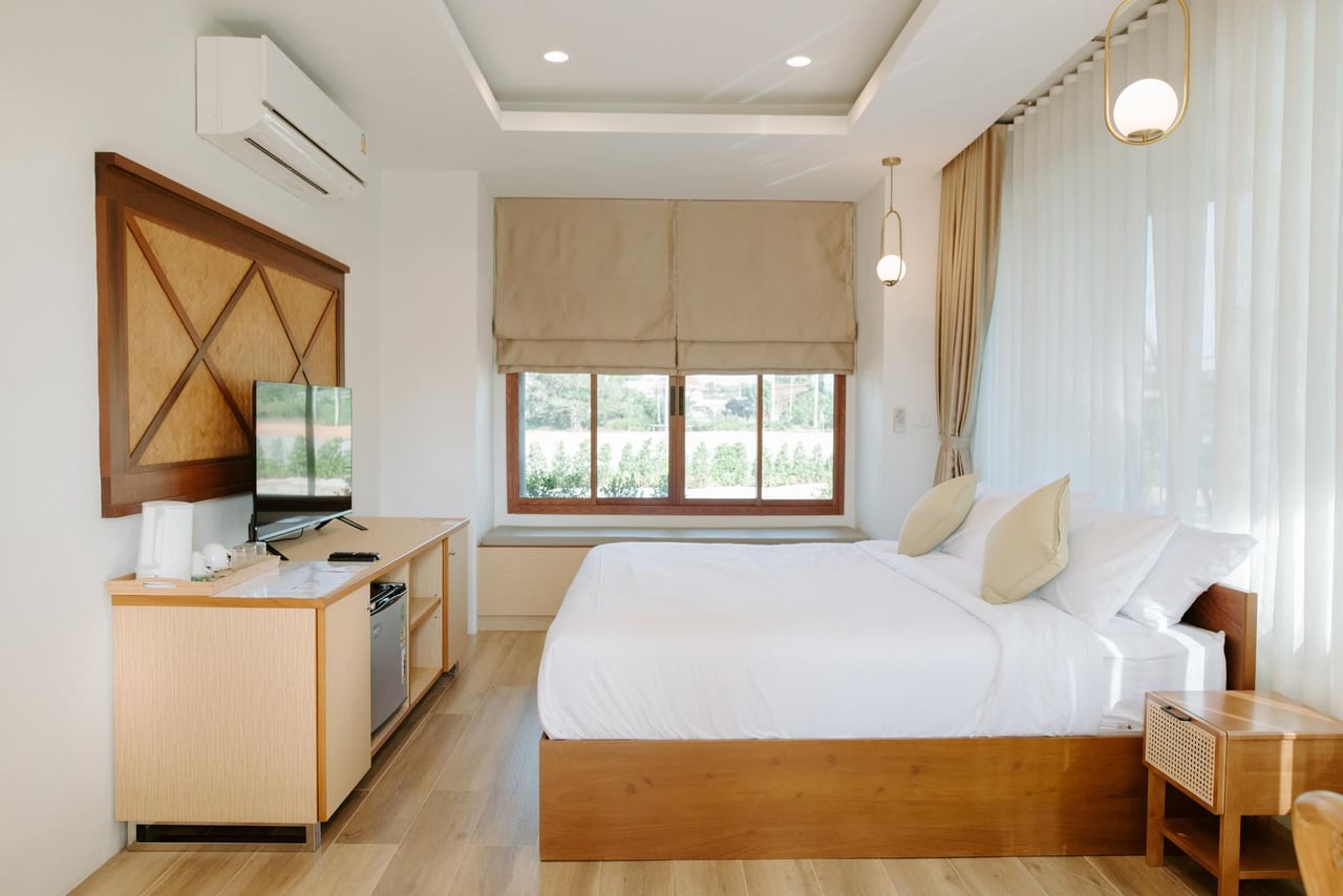 ห้องพัก Ellipse Boutique Phayao ผนังขาว แผงไม้ไผ่สานลายเฉียงด้านผนังทีวี เตียงคิงไซส์