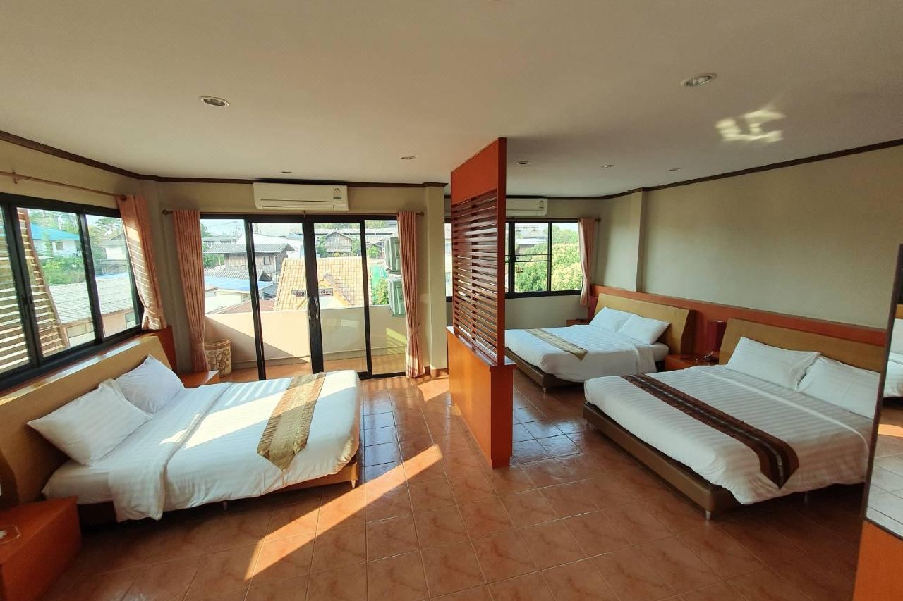 ห้อง Deluxe ขนาดใหญ่ Kwan Phayao Villa มีหลายเตียงและระเบียงมองเห็นหลังคาบ้านในเมือง