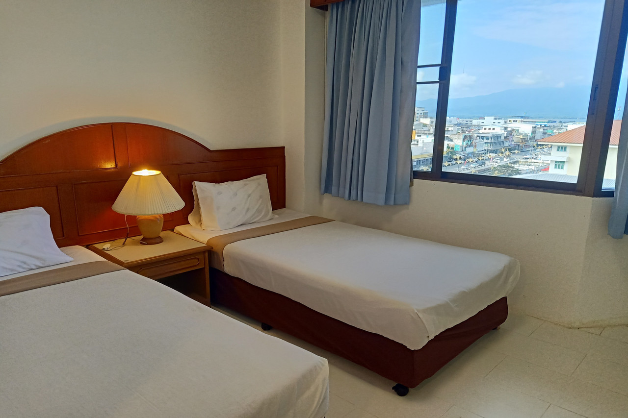 ห้องพักเตียงคู่ของ Phayao Lake Hotel มองเห็นวิวเมืองพะเยาผ่านหน้าต่าง