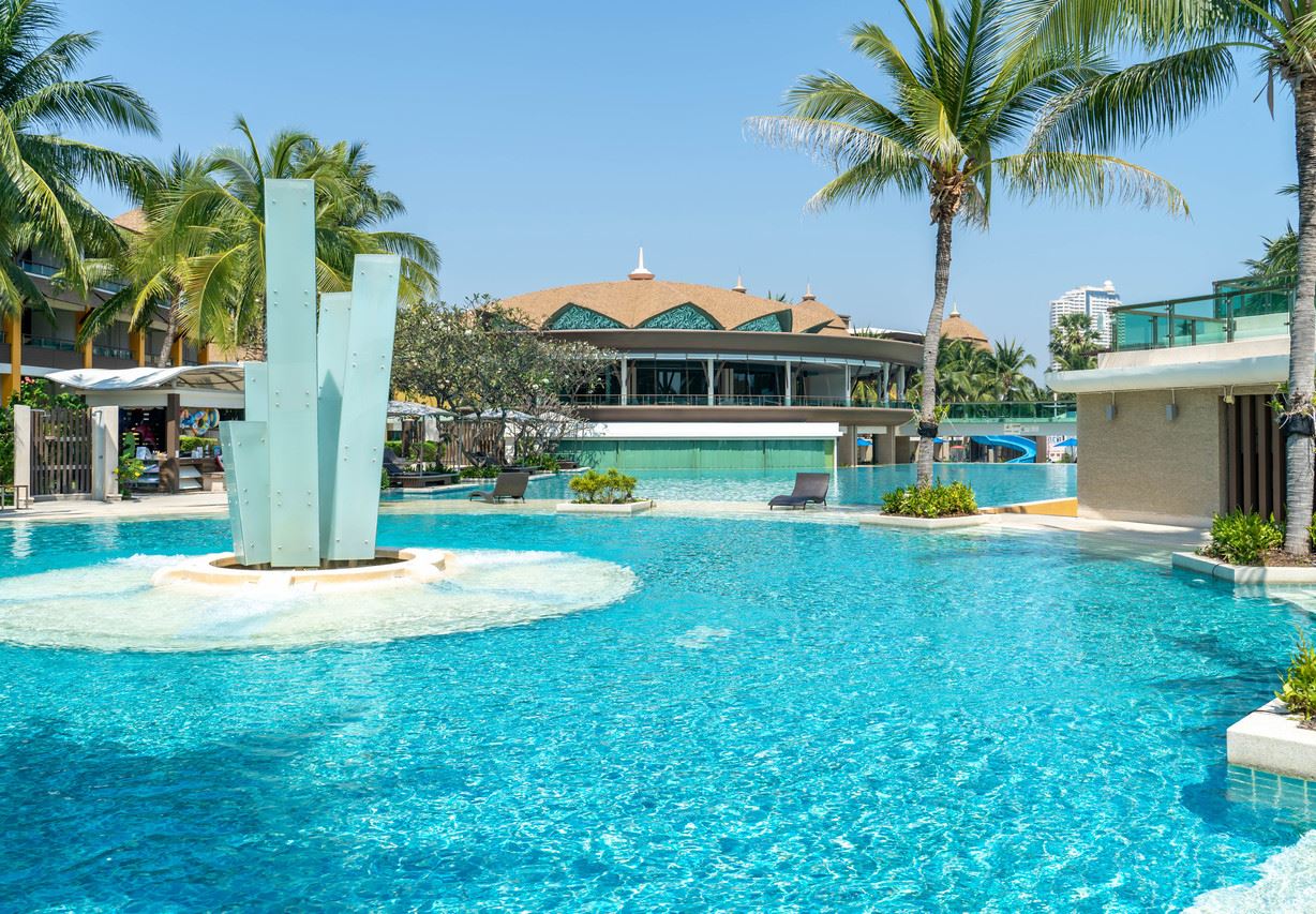สระว่ายน้ำลากูนพร้อมน้ำพุประติมากรรมและอาคารหลังคาทรงไทยของ Springfield @Sea