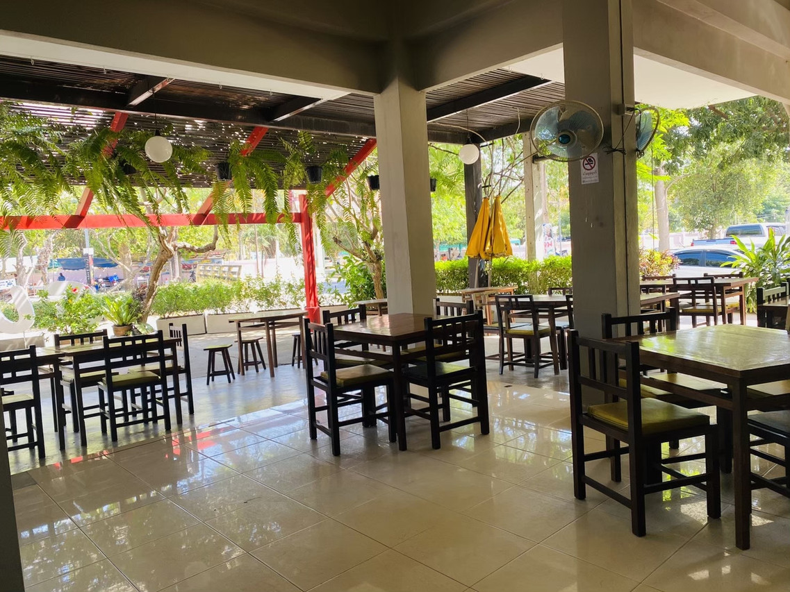 ห้องอาหารกึ่งกลางแจ้ง โต๊ะไม้และพัดลมเพดานที่ Sun Hotel Phetchaburi